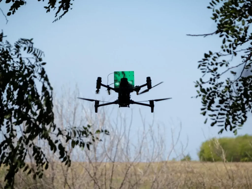 Un piloto de drones profesional opera su equipo en un campo abierto.