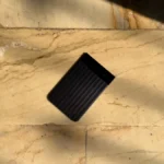 El Plaud Note Pro junto a una tarjeta de crédito para comparar su grosor.